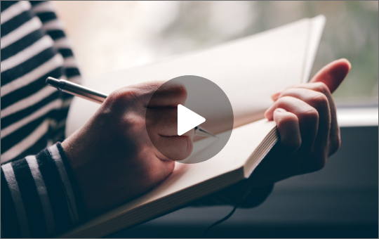 Eine Person die ein paar Zeilen in ein Buch schreibt