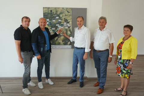 LR Schneemann sieht sich mit Vizebürgermeister und Ortsvorsteher Reinhard Kuktits die Luftaufnahme von Spitzzicken in den neu gebauten Räumlichkeiten des Begegnungszentrums in der Volksschule Spitzzicken an