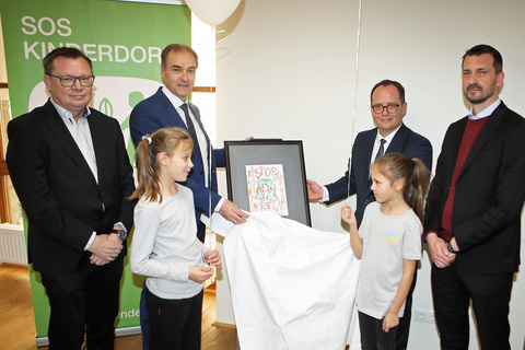 Landesrat Dr. Leonhard Schneemann (2.v.l., hinten) mit SOS-Kinderdorf-Leiter Burgenland Mag. Marek Zeliska, Leiter der Friedensburg, Mag. Norbert Darabos, SOS-Kinderdorf-Leiter Burgenland Mag. Marek Zeliska und ACP Direktor Mag. Moritz Ehrmann (hinten v.l.), mit zwei ukrainischen Kindern, die symbolisch ein Bild enthüllten.