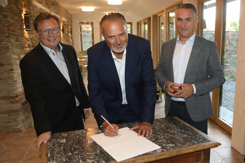 Landeshauptmann Hans Peter Doskozil mit Burgkoordinator Norbert Darabos und Bürgermeister Markus Szelinger (v.l.) bei der Unterschrift des Dokuments für die Zeitkapsel