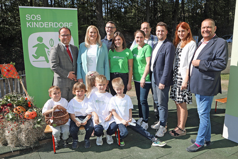 Bildungslandesrätin Daniela Winkler (2.v.l., stehend) mit Kindern des SOS Kinderdorfes Pinkafelds sowie SOS Kinderdorfleiter Marek Zeliska (links, stehend), Mitarbeiterinnen des SOS Kinderdorfes Pinkafeld und Vizebürgermeistern, Stadt- und Gemeinderäten.