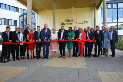 Symbolisches Durchschneiden des Bades vor dem Haupteingang der Klinik