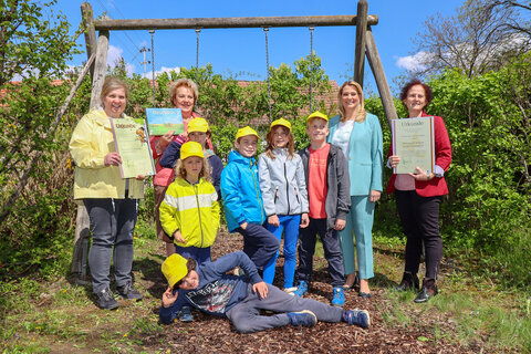 Zertifikat „Naturparkkindergarten“ und „Naturparkschule“ für den Kindergarten und die Volksschule Moschendorf. LRin Mag.a (FH) Daniela Winkler (2.v.r.) und LT-Präs.in Verena Dunst (2.v.l.) mit Kindergartenleiterin Hannelore Gratzer (1.v.l.), Direktorin der VS Moschendorf Claudia Taucher (1.v.r.) und Volksschulkindern
